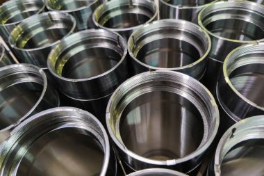 a close-up shot of shiny steel aerospace cnc turned tubes in a batch with selective focus and background blur