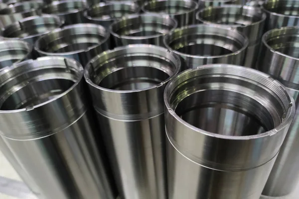 Um close-up de aço brilhante aeroespacial cnc virou tubos em um lote com foco seletivo e borrão de fundo — Fotografia de Stock