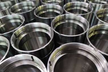a close-up shot of shiny steel aerospace cnc turned tubes in a batch with selective focus and background blur