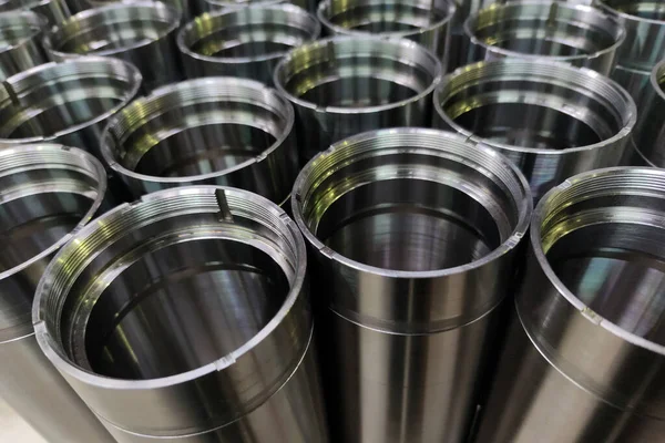 A close-up shot of shiny steel aerospace cnc turned tubes in a batch with selective focus and background blur — Stockfoto