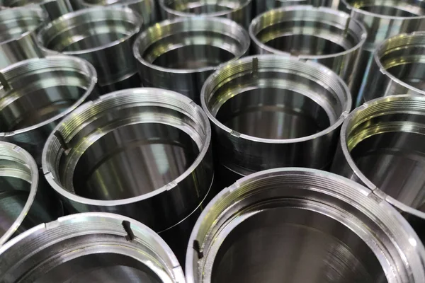 A close-up shot of shiny steel aerospace cnc turned tubes in a batch with selective focus and background blur — 图库照片