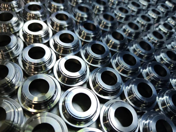 Sfondo parti in acciaio lucido. Modello di produzione industriale regolare di metallo con focus selettivo . — Foto Stock