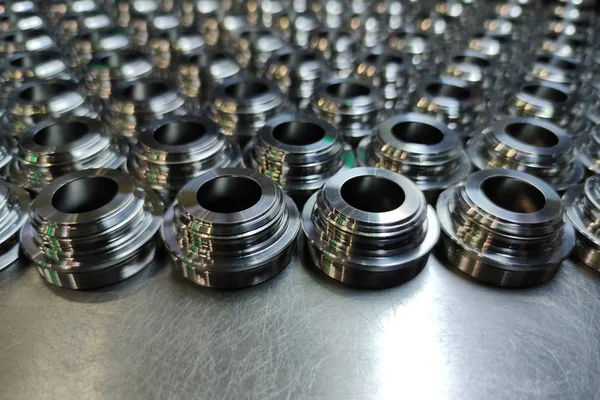 Um lote de metal brilhante cnc produção de peças aeroespaciais - close-up com foco seletivo para fundo industrial — Fotografia de Stock