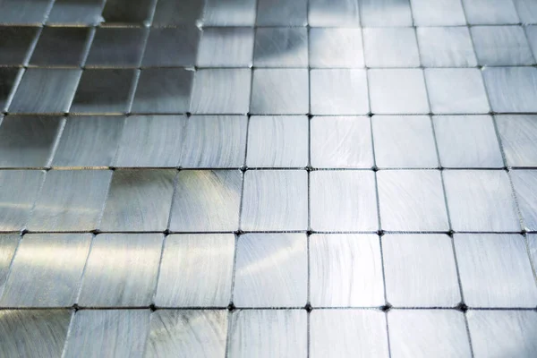 Glanzend staal bewerkt blokken bestrating oppervlak achtergrond - close-up met selectieve focus en wazig — Stockfoto
