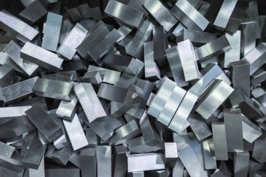 a pile of shiny faceted steel blocks - full frame close-up with selective focus