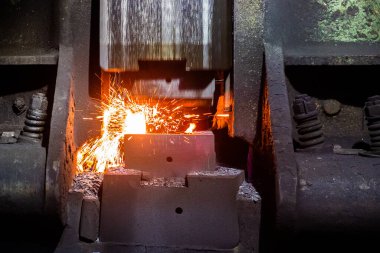 Büyük mekanik çekiç makinesi ile sıcak çelik demirleme işleminin ön görüntüsü