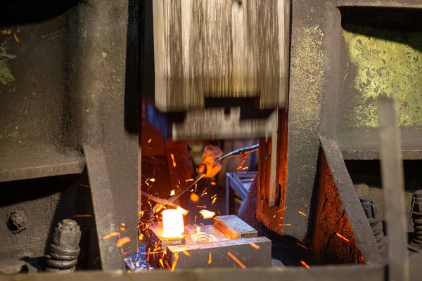 Крупним планом картина процесу кування гарячої сталі з великим механічним молотком — стокове фото