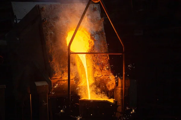 Un proceso de llenado de cucharón con acero caliente fundido del horno con humo: primer plano con enfoque selectivo —  Fotos de Stock