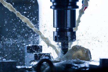 Harici su soğutucu akımları, sıçramalar ve bir sürü metal parçacıkları olan dikey cnc çelik fabrikası. Hareket donması için hızlı deklanşör hızı. Sığ alan derinliği.