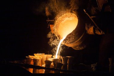 Endüstri balmumu döküm kaybetti. Seramik kabukları erimiş çelikle doldurma işlemi.
