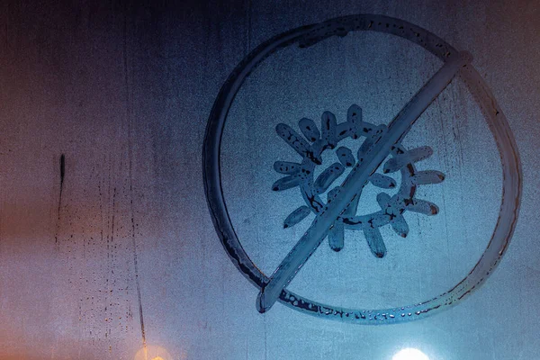 Заборонений значок коронавірусу, написаний вручну на нічному мокрій склянці вікна крупним планом — стокове фото