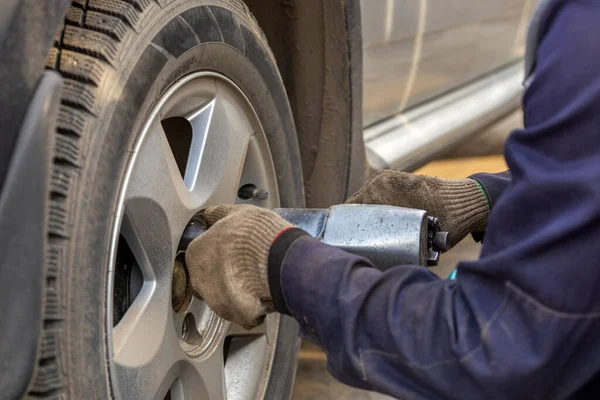Handen van automotive monteur schroeven moeren met pneumatische slagmoersleutel tijdens auto wielen seizoen veranderen — Stockfoto
