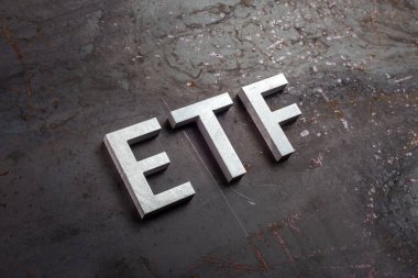 Kısaltma sözcüğü etf - Ticaret Fonu - eğimli köşegen perspektifte ham çelik yüzey üzerine gümüş harflerle döşenmiş