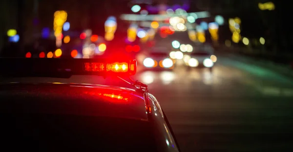 Поліцейські автомобільні вогні в нічному місті з вибірковим фокусом і боке — стокове фото