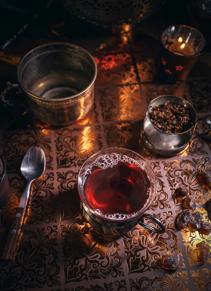 Black tea in cup and candles — Stock Photo, Image