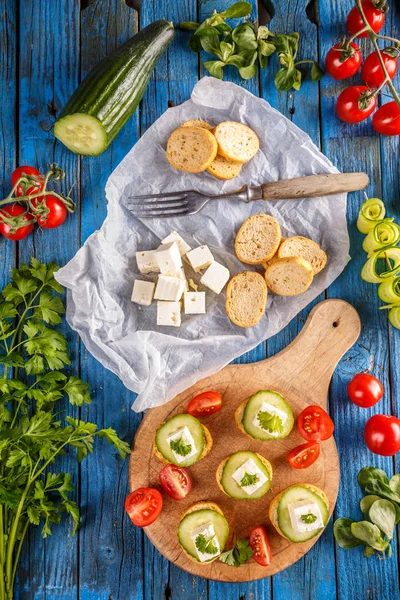 Ruscos de pan rematados con un cubo de feta — Foto de Stock