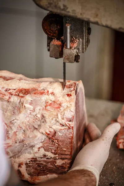 Açougueiro está cortando carne de vaca — Fotografia de Stock