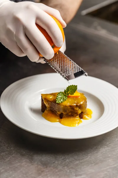 Chef rasping orange zest — Stock Photo, Image