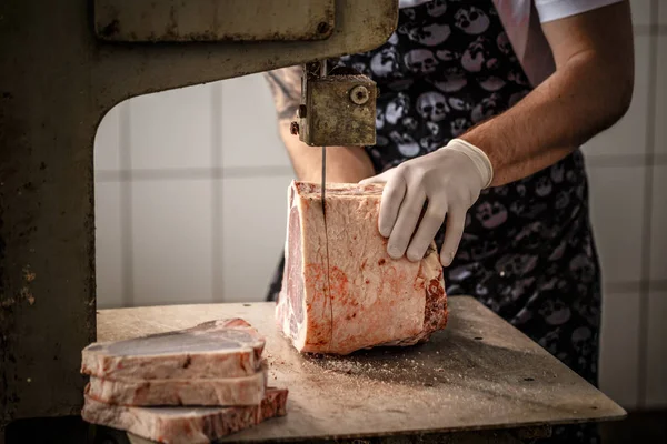 Рабочий режет мясо говядины — стоковое фото