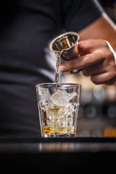 Barman is pouring alcohol from a jigger — Stock Photo, Image