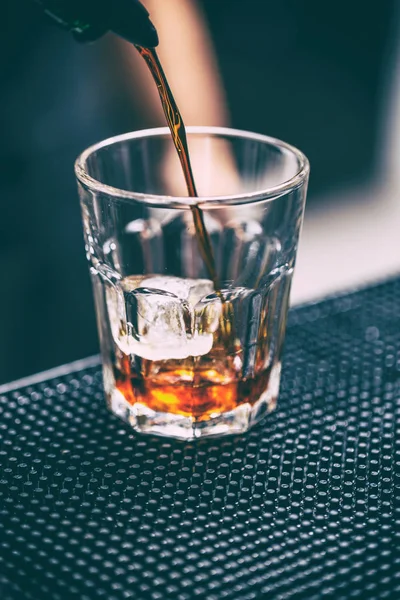 Bartender pours alcoholic drink — Stock Photo, Image