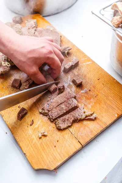 Кухар розрізає варене м'ясо з яловичини Ліцензійні Стокові Зображення