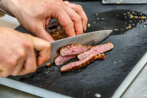 Chef está cortando carne — Fotografia de Stock