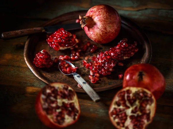 Pomegranate seeds in a metal spoon — Stock Photo, Image