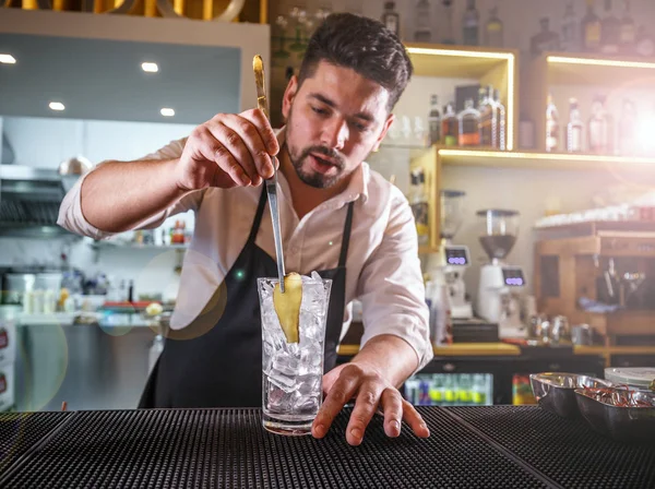 Barman adicionando gengibre em um copo — Fotografia de Stock