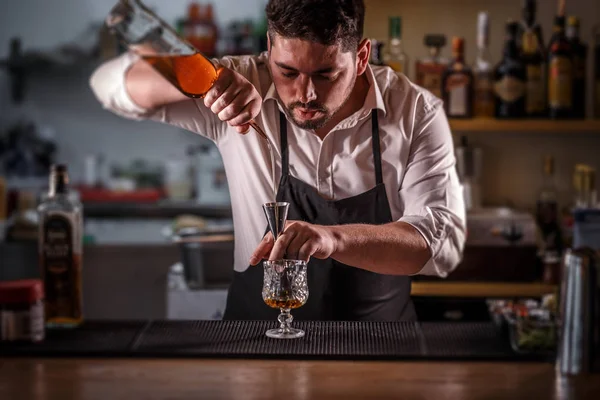 Barman derramando mistura em um jigger — Fotografia de Stock