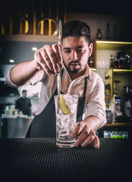 Barman toevoegen van gember in een glas Stockafbeelding