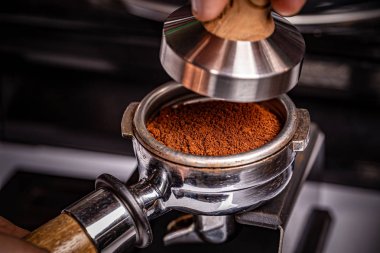 Barista kurcalayıcı kullanıyor.