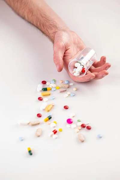 Flerfärgade piller i manshand — Stockfoto