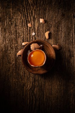 Eski ahşap arka planda kırılmış çiğ çiftlik yumurtası.