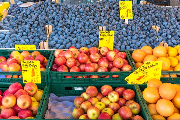 Jablka, pomeranče a švestky na prodej — Stock fotografie