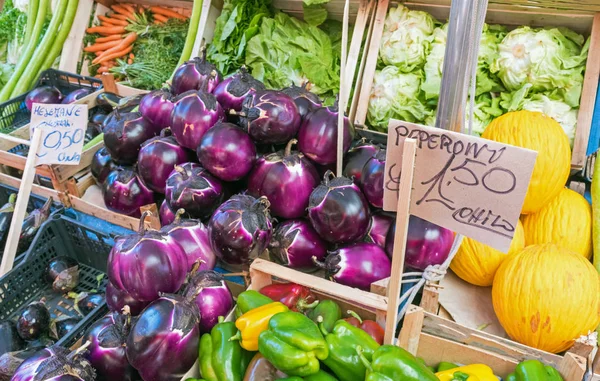 Fresh aubergines and salad at a market — Stock Photo, Image