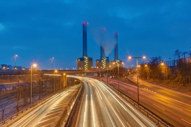 Power station and highway at night seen in Berlin, Germany clipart