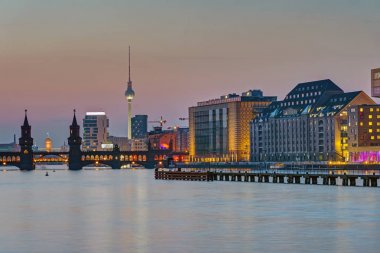 Arka tarafta televizyon kulesi ile Berlin'de Spree Nehri, alacakaranlıkta