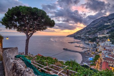 İtalya 'da gün batımında yalnız bir çam ağacıyla Amalfi manzarası