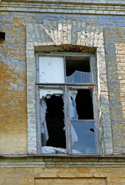 Terk edilmiş eski bir evde kırık bir pencere..