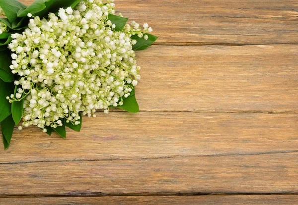 Bouquet lily of the valley on wooden table.