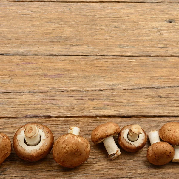 Champignon mushrooms on old wooden table. Top view. — Stock Photo, Image