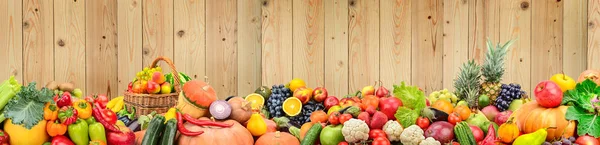 Panoramiczne zdjęcie zdrowe warzywa i owoce przed jasnym drewnem — Zdjęcie stockowe