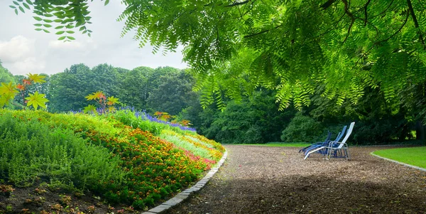 五颜六色的花坛和在阳光明媚的下午休息的地方 — 图库照片