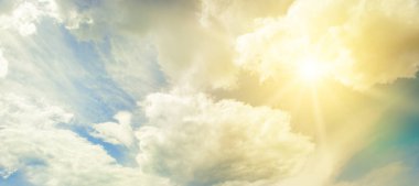 Güneş mavi gökyüzünde güzel beyaz bulutlarla.