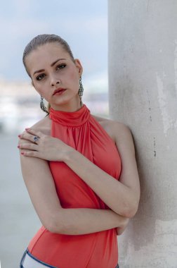 Genç güzel sarışın kız bir kırmızı yaz bluz ve kot pantolon esnek poz