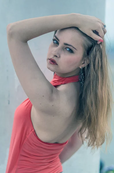 Ung vacker blond tjej i en röd sommar blus och jeans poserar flexibla — Stockfoto
