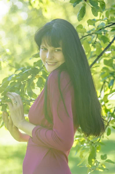 Młoda Dziewczyna Brunetka z piegami w czerwonej sukience w ogrodzie — Zdjęcie stockowe