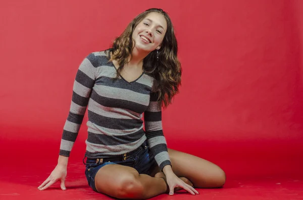 Young cheerful girl in denim shorts and a striped sweater walking in the youthful style — Stock Photo, Image