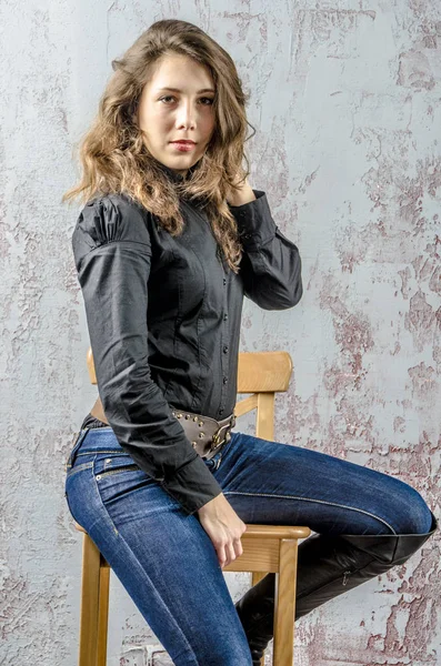 Junges Mädchen mit lockigem Haar in schwarzem Hemd, Jeans und hohen Stiefeln Cowboy-Western-Stil — Stockfoto